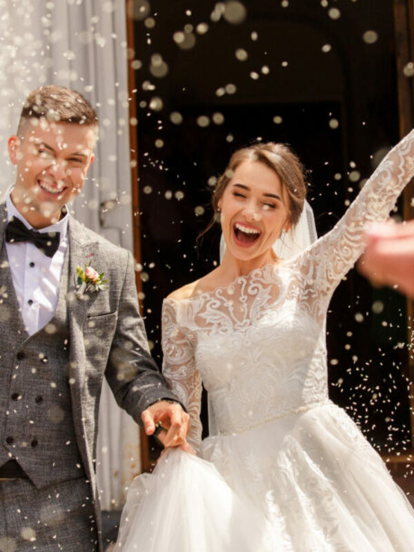 Happy wedding photography of bride and groom at wedding ceremony. Wedding tradition sprinkled with rice and grain